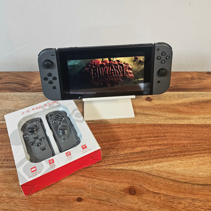 Graue Controller an einer Nintendo Switch mit Produktverpackung