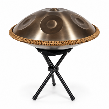 Goldfarbene Handpan mit geflochtenem Rand auf dem mitgelieferten schwarzen Ständer
