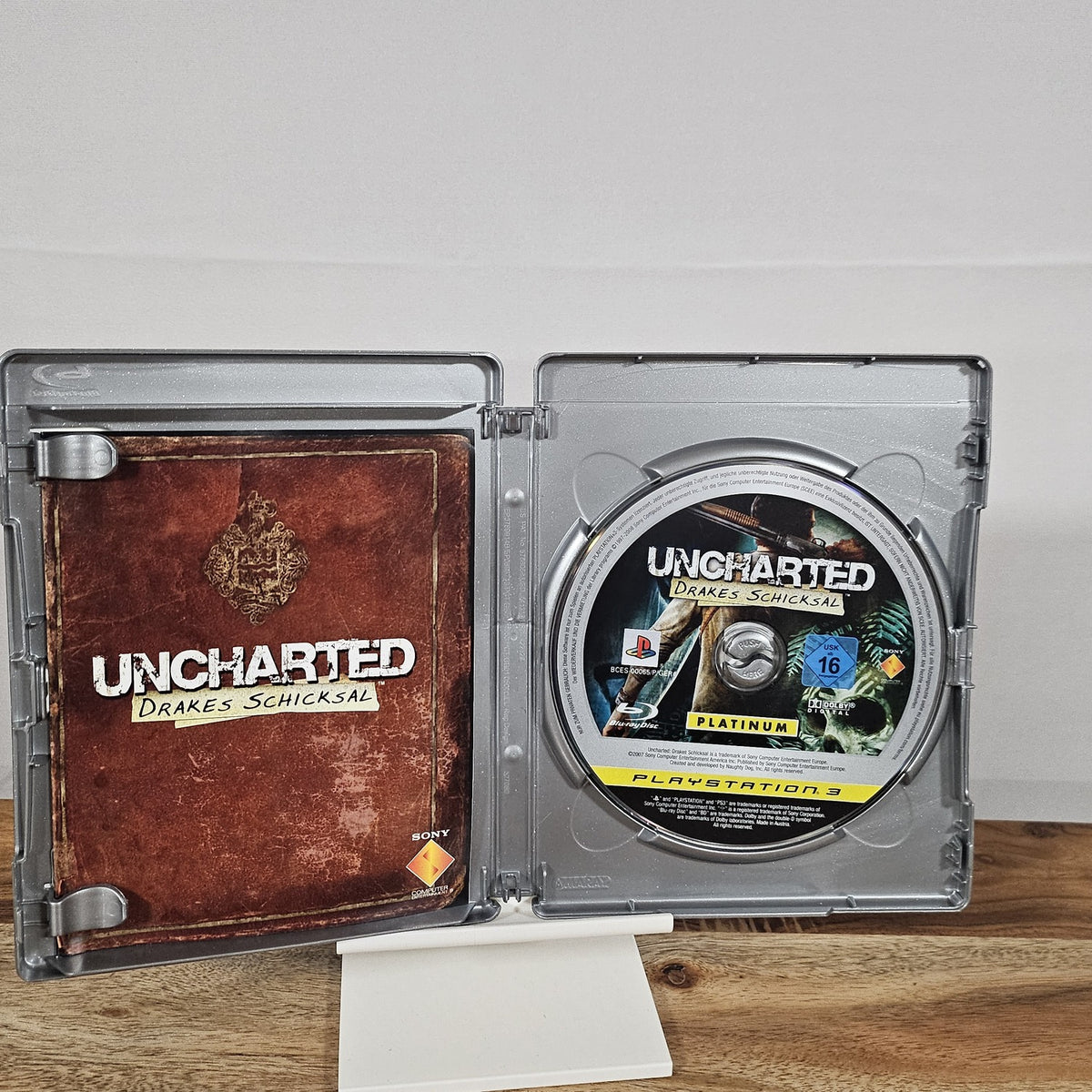 Uncharted 2: Among Thieves Platinum für PlayStation 3 – geöffnete Originalhülle mit Spiel-Disc und Unterlagen