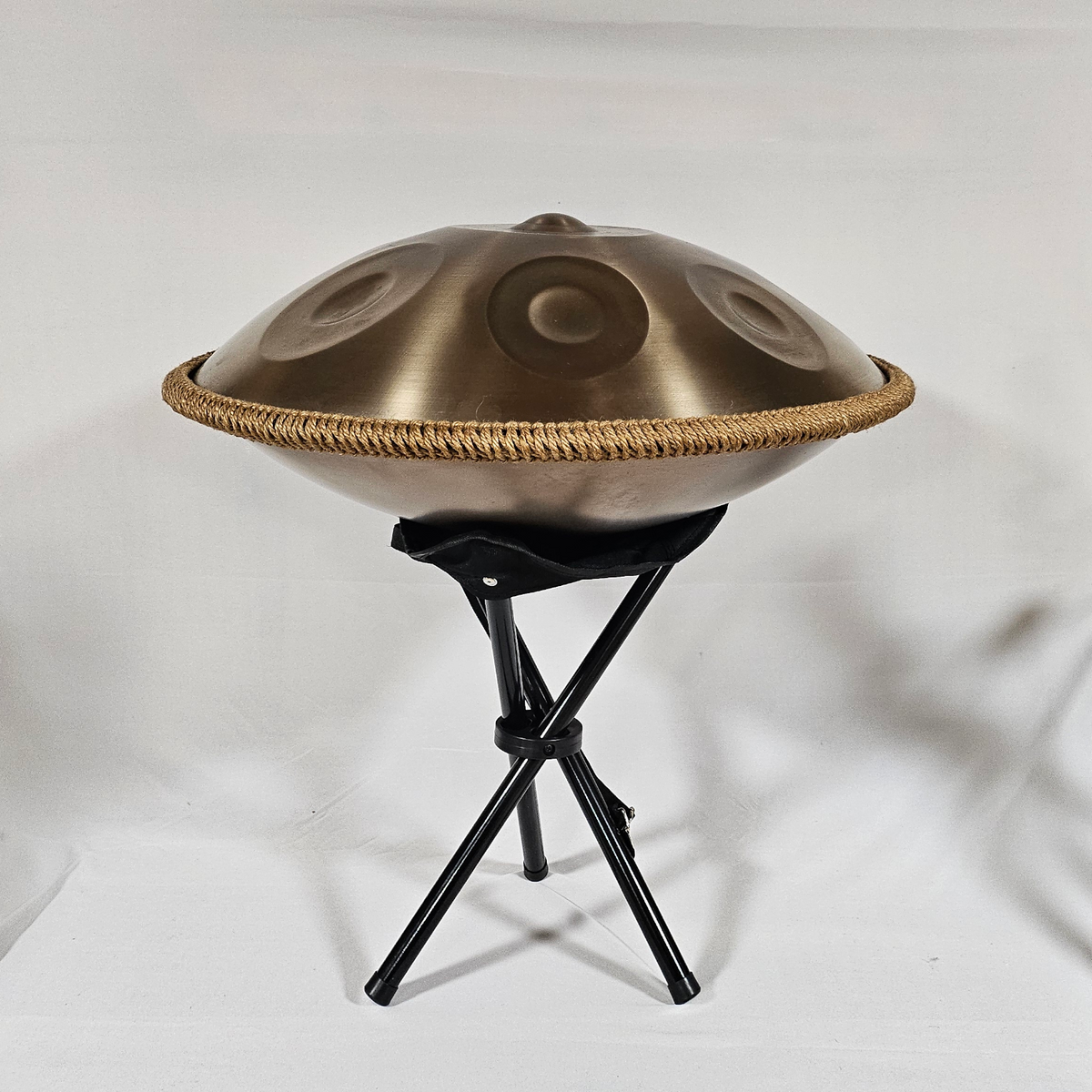 Echtes Lagerfoto der goldfarbenen Handpan auf dem schwarzen Klappständer