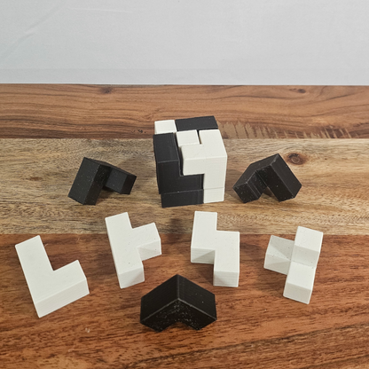 Alle sieben schwarz-weissen Puzzle-Teile des 3D-gedruckten Soma-Würfels