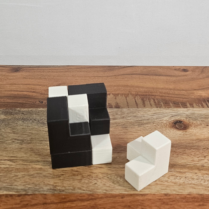 Teilweise zerlegter Soma-Rätselwürfel mit einem einzelnen weissen Puzzle-Teil