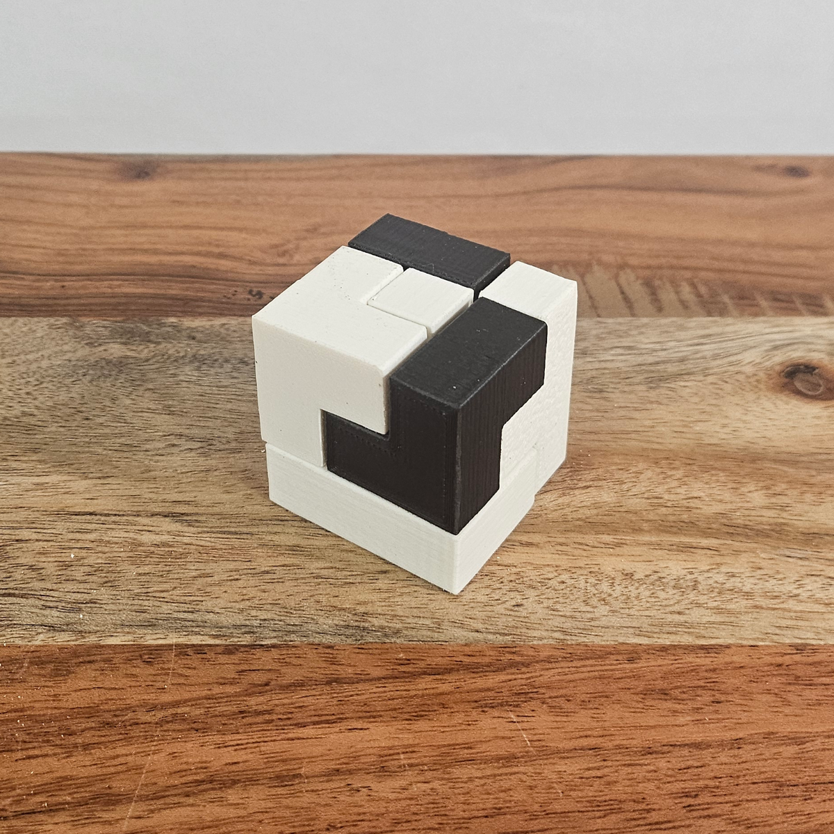 Zusammengesetzter schwarz-weisser Soma-Rätselwürfel auf einem Holztisch