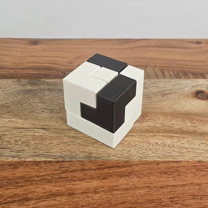 Zusammengesetzter schwarz-weisser Soma-Rätselwürfel auf einem Holztisch